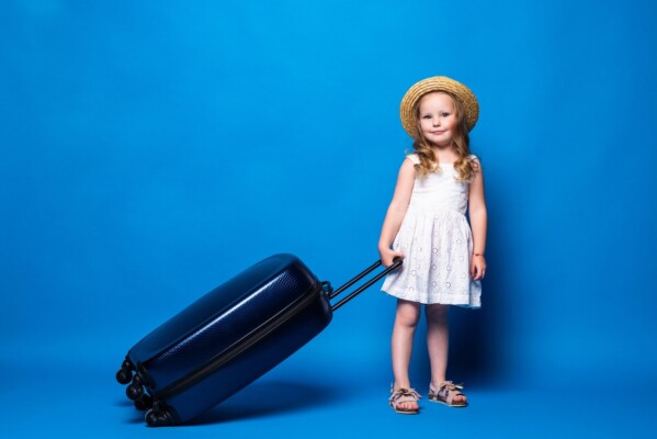 A picture of a child holding a black traveling bag